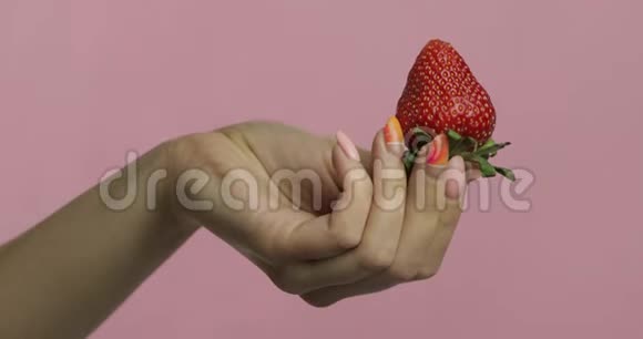 女人的手拿着草莓在浆果上面挤出鲜奶油视频的预览图
