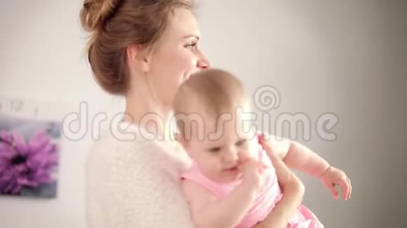 可爱的妈妈手里拿着小宝宝开朗的女人微笑的女孩视频的预览图