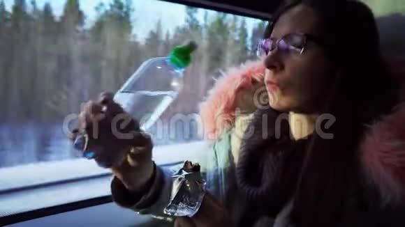 戴眼镜的年轻女子在冬天乘火车旅行视频的预览图