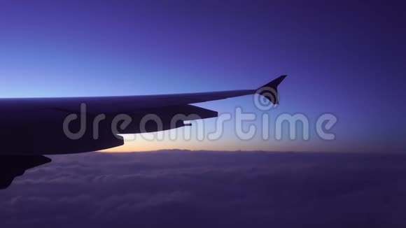 飞机的翅膀在天空中的云层与日落视频的预览图