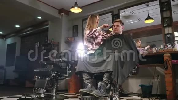 男子客户参观理发店的理发师和发型师的后视图视频的预览图