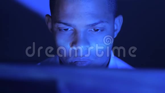 一个年轻忙碌的非洲商人晚上在电脑上工作视频的预览图