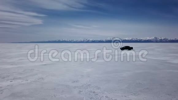 在冬季景观中驾驶汽车的无人机空中景观和高速驾驶过冰冻的湖泊视频的预览图