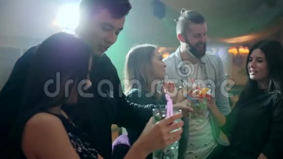 五个快乐的朋友在酒吧柜台附近的一个俱乐部里用酒精鸡尾酒祝酒视频的预览图