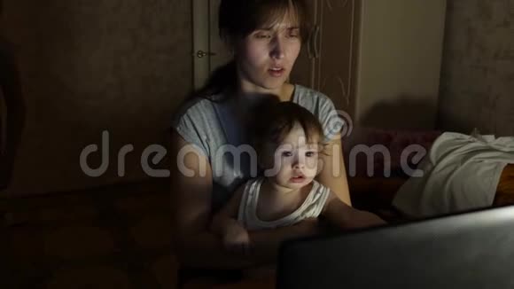 抱着孩子的女人在电脑上交流视频的预览图