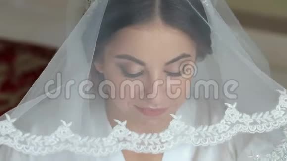 漂亮的新娘肖像早上化妆在靠近窗户的房间里视频的预览图