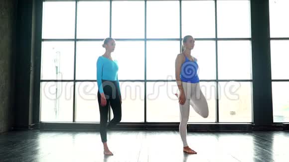瑜伽女孩一起在大窗户背景下做瑜伽年轻女性做瑜伽女人上瑜伽课视频的预览图