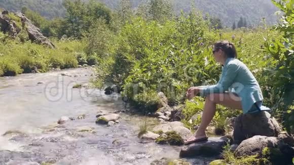 旅行妇女坐在河岸上欣赏美丽的风景视频的预览图