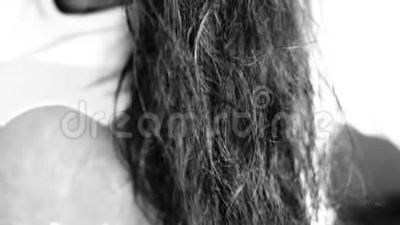 一个没有脸的年轻少女棕色头发梳理她的头发和干燥的头发视频的预览图