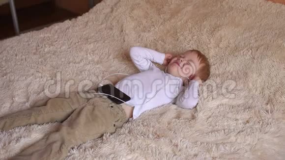 一个小男孩戴着耳机躺在床上视频的预览图