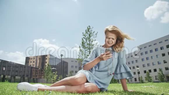 漂亮的年轻女人在户外用手机上网视频的预览图