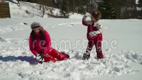 快乐的一家人在冬天的雪山上玩得很开心妈妈和儿子玩雪球视频的预览图
