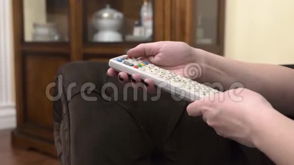 女人按遥控器上的按钮视频的预览图