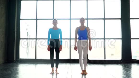 两个可爱的瑜伽女人一起在有大窗户的工作室做瑜伽年轻女性做瑜伽女人上瑜伽课视频的预览图