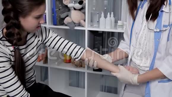 一位年轻的医生在他的办公室里检查一个病人孩子视频的预览图