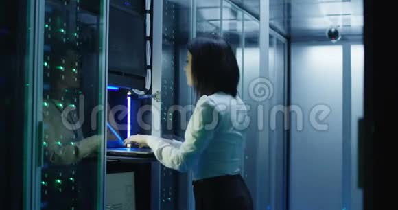 女技术员在数据中心的笔记本电脑上工作视频的预览图
