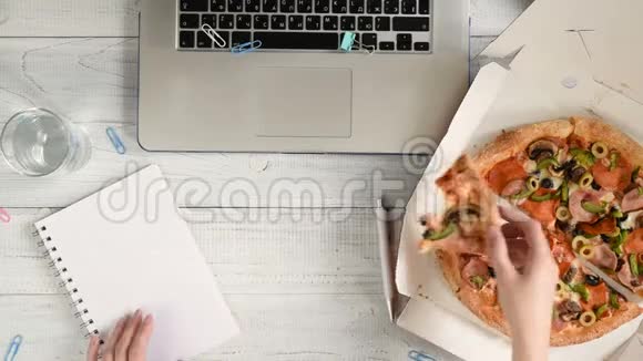 女商人用手提电脑在办公桌上工作吃午饭视频的预览图