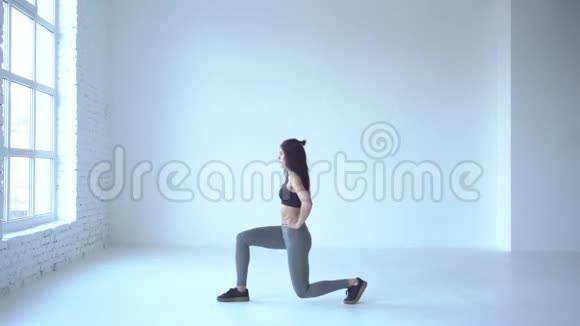 步行弓步练习运动教练正在白工作室热身4k镜头视频的预览图