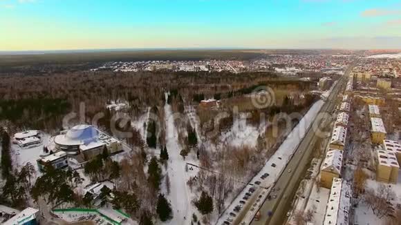 直升机飞过冬天的城市靠近森林公园游憩区视频的预览图