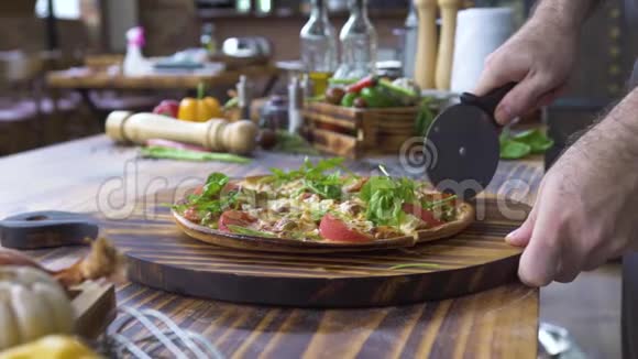 厨师用刀切比萨饼的手在木桌上食物背景在餐厅完成切热披萨的过程视频的预览图