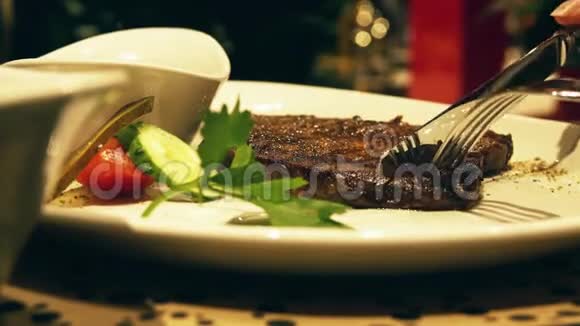 在餐厅吃多汁的热气腾腾的牛排盘子特写镜头视频的预览图