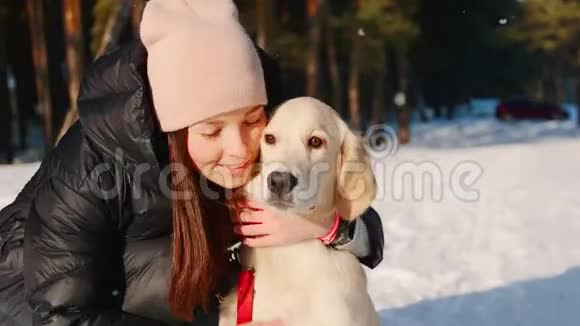 女人在冬天的森林里拥抱一只狗视频的预览图