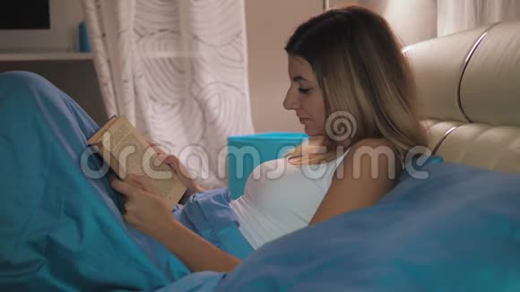 女人睡觉前在房间的封面下躺在床上看书视频的预览图
