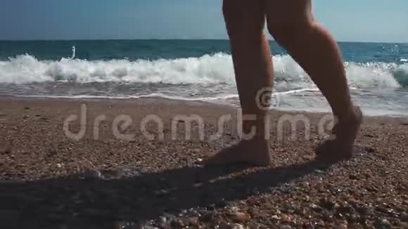 度假的女人正在海边散步她光着脚和腿的详细景色视频的预览图