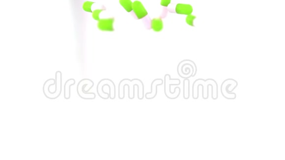 绿色和白色药物胶囊或药片散落在桌子上视频的预览图
