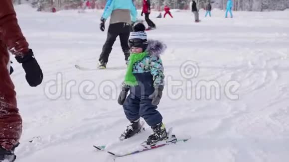 这个孩子和一个教练一起学习滑雪滑雪胜地积极运动视频的预览图
