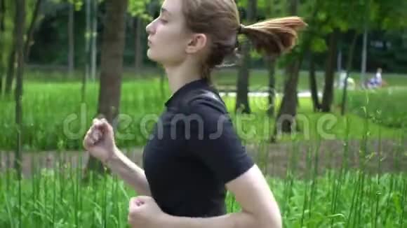 年轻的运动女子在夏天跑公园慢动作视频的预览图