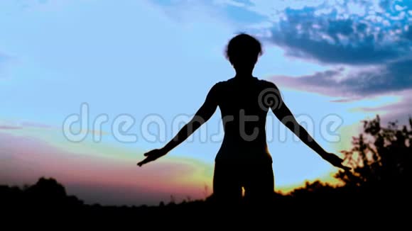 天空背景下的和谐女人的剪影她参与了瑜伽的体操视频的预览图