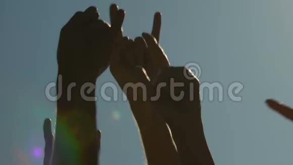 男女双方举起手在露天摇滚音乐会上向音乐挥手视频的预览图