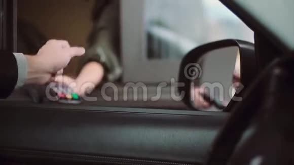 男子支付信用卡购买内部汽车输入一个PIN代码从车窗上近距离观看商人手视频的预览图