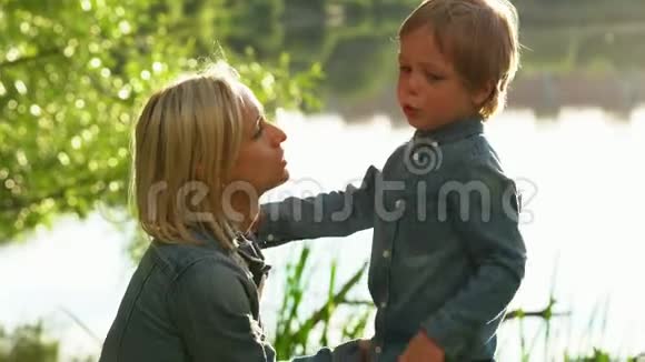 愤怒的小男孩在夏天公园拥抱他的母亲视频的预览图