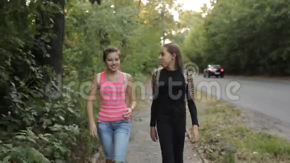 两个十几岁的女孩站在路边谈笑风生视频的预览图