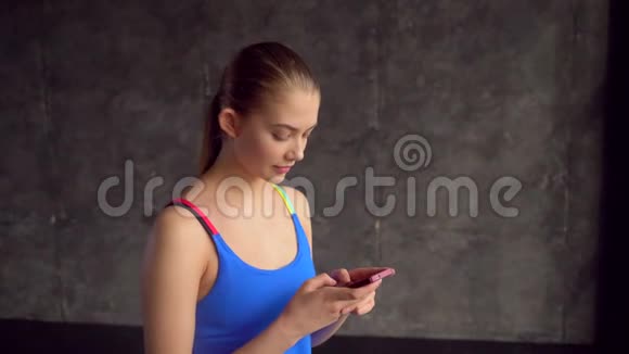 健康女性使用健身可穿戴技术在健身房锻炼后在智能手机上检查身体统计数据视频的预览图