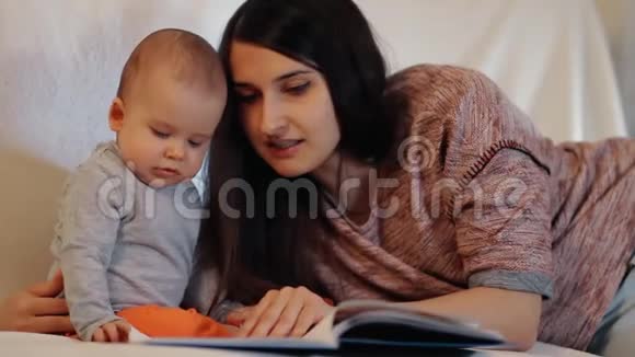 一位年轻的母亲和一个正在看书的小孩慢镜头视频的预览图