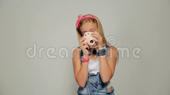 年轻的时髦女孩手里拿着回形镜头拍摄照片视频的预览图