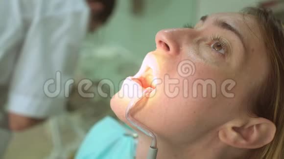 牙科门诊美女病人脸与牙医手的特写视频的预览图