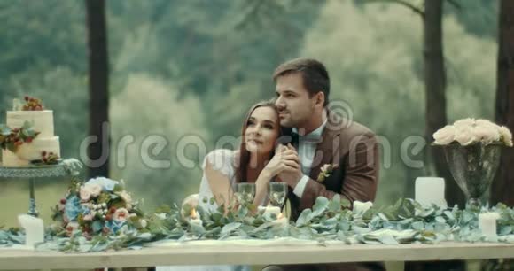爱的一对夫妇在雾蒙蒙的森林里浪漫的约会中温柔地拥抱和牵手美味的水果蛋糕视频的预览图