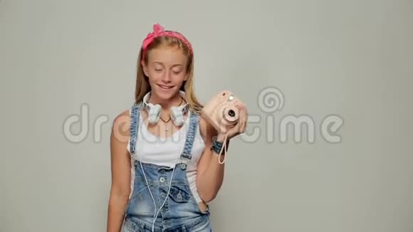 年轻的时髦女人拿着回形针拍照像视频的预览图