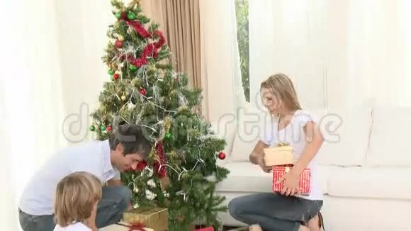 一家人在家的圣诞树旁玩礼物视频的预览图