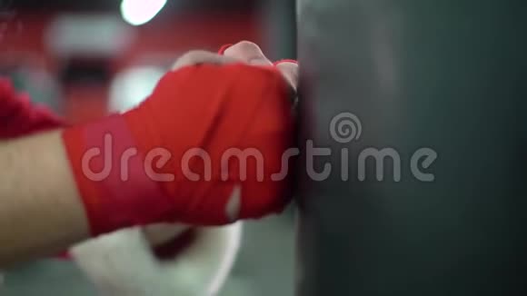 圣诞老人拳击手和红色绷带拳击手在拳击工作室打一个巨大的拳击袋圣诞老人拳击手视频的预览图