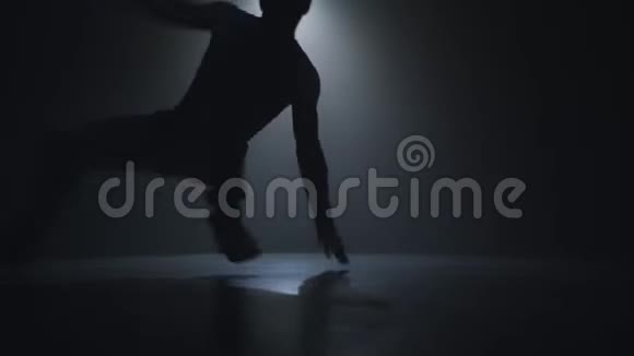 一位才华横溢的年轻舞者在聚光灯前的舞台上跳嘻哈街舞的剪影视频的预览图