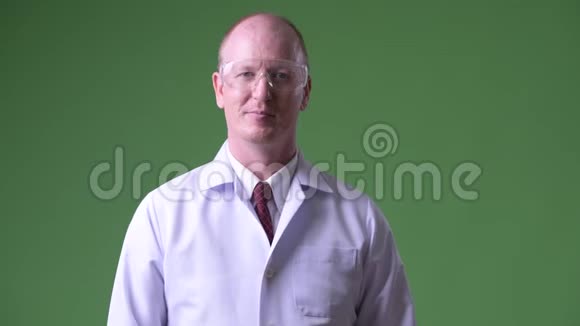 快乐成熟的秃头医生戴着防护眼镜视频的预览图