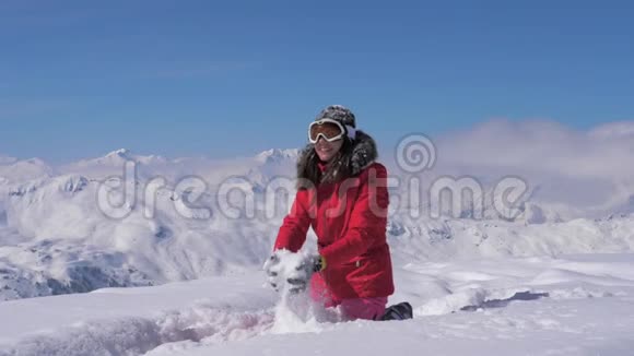 快乐的女人在阳光明媚的日子里在山上玩雪慢动作高清视频的预览图