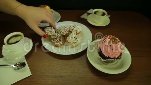 女人把蛋糕放在白色盘子里喝咖啡视频的预览图