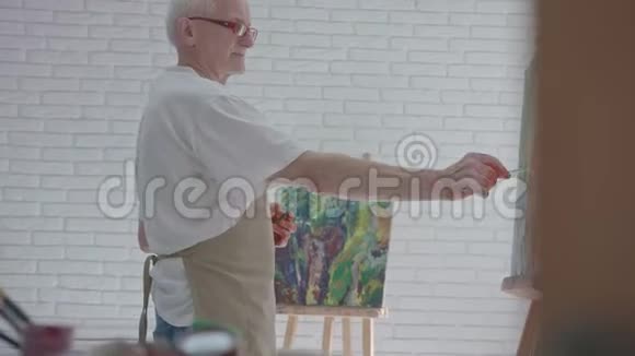 在阿泰利耶工作的老艺术家用五颜六色的颜料视频的预览图
