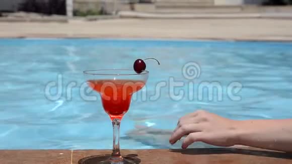 年轻女子穿着泳衣在杯中加入新鲜的西瓜或草莓喝杯鸡尾酒坐着喝一杯视频的预览图